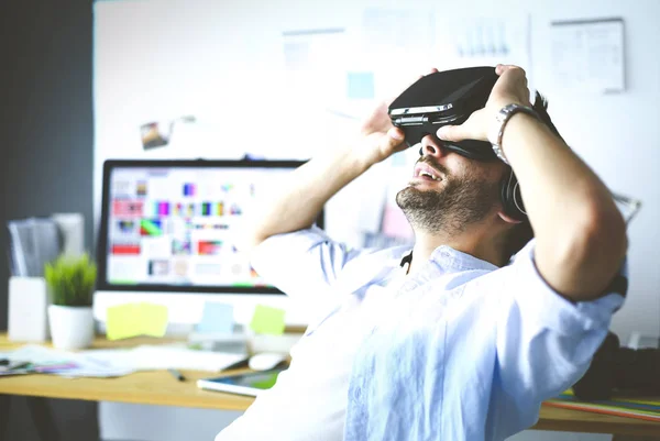 Jovem programador de software masculino testando um novo aplicativo com óculos de realidade virtual 3d no escritório — Fotografia de Stock