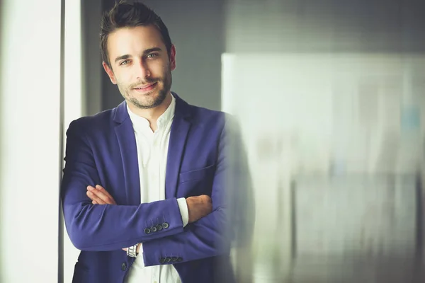 Retrato del joven diseñador frente a la computadora portátil y el ordenador mientras trabaja — Foto de Stock