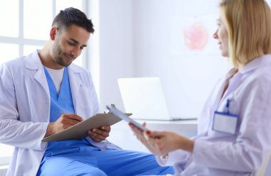 Genç ve kendinden emin doktorların portresi tıp ofisinde duruyor.