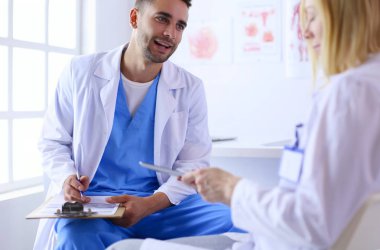 Genç ve kendinden emin doktorların portresi tıp ofisinde duruyor..