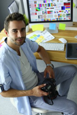 İnternette çalışırken bilgisayarın ve dizüstü bilgisayarın önünde grafik stüdyosunda oturan genç tasarımcının portresi