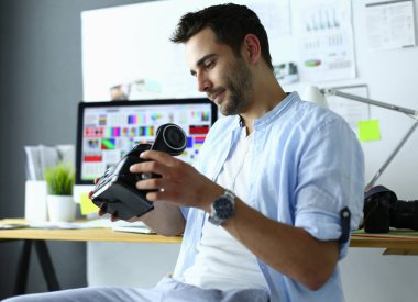 Genç erkek yazılım programcısı ofiste üç boyutlu sanal gerçeklik gözlükleriyle yeni bir uygulama test ediyor.