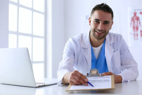 Porträt eines männlichen Arztes mit Laptop am Schreibtisch in der Arztpraxis — Stockfoto