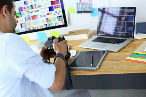Porträt eines jungen Designers, der im Grafikstudio vor Laptop und Computer sitzt, während er online arbeitet — Stockfoto