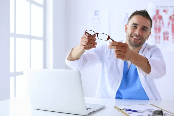 Porträt eines männlichen Arztes mit Laptop am Schreibtisch in der Arztpraxis — Stockfoto