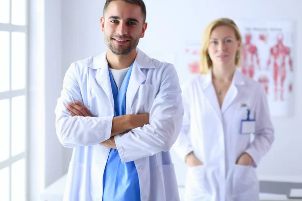Jonge en zelfverzekerde artsen portret staan in het medisch kantoor — Stockfoto