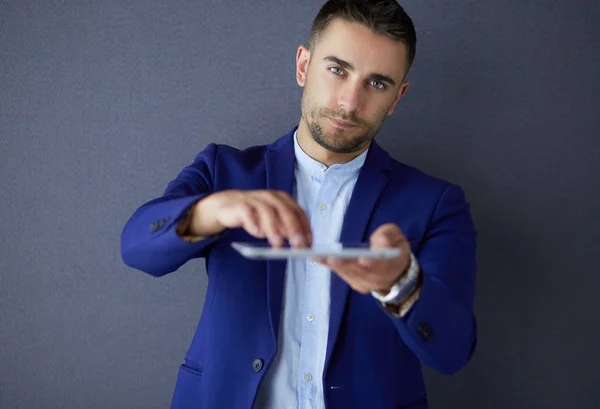 Glücklicher junger Mann mit digitalem Tablet isoliert auf grauem Hintergrund — Stockfoto
