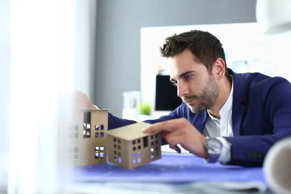 Homme d'affaires tenant maison miniature à portée de main debout dans le bureau — Photo