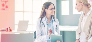 Doktor ve hasta masada otururken bir şey tartışıyorlar. İlaç ve sağlık hizmetleri kavramı