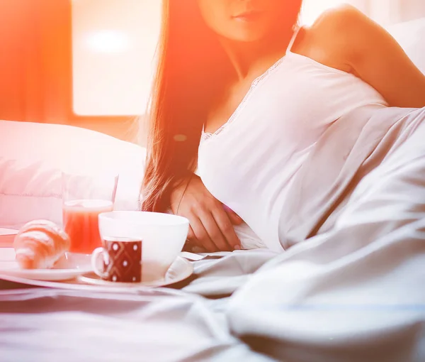Sarapan di tempat tidur dengan kopi dan croissant untuk wanita muda yang menarik — Stok Foto