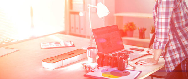 Женщина-фотограф сидит на столе с ноутбуком. Женщина-фотограф
