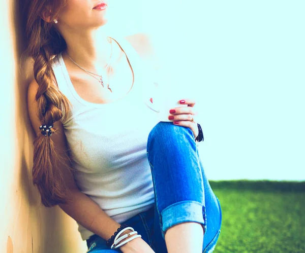 Ung kvinna sitter med boken på gräs — Stockfoto