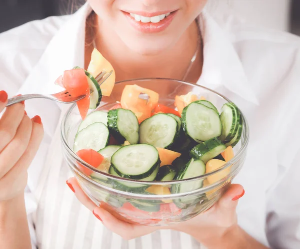 Jovem mulher comendo salada fresca na cozinha moderna — Fotografia de Stock