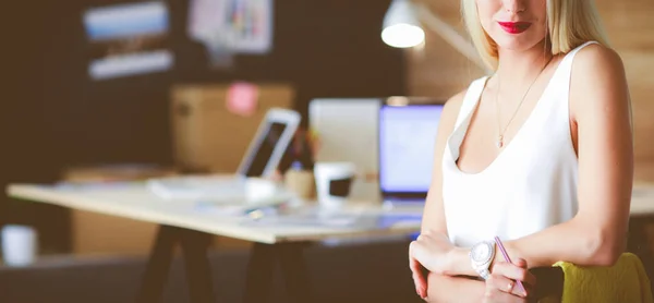 Porträt einer professionellen Geschäftsfrau, die auf einem Bürotisch sitzt — Stockfoto