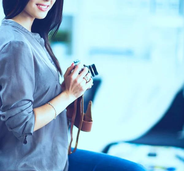 Mujer joven viendo imágenes en la película, de pie cerca de la ventana —  Fotos de Stock