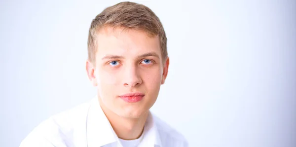 Retrato de un joven sonriendo sentado sobre un fondo gris. Retrato del joven — Foto de Stock