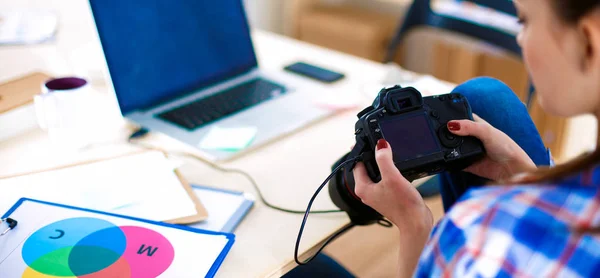 Vrouwelijke fotograaf zittend op het bureau met laptop — Stockfoto