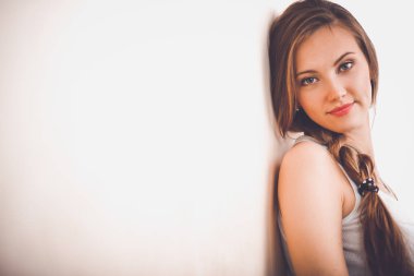 Duvarının yakınında katta oturan bir genç bayan. Genç kadın