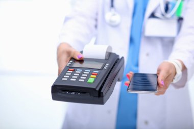 Doktor ödeme terminalini elinde tutuyor. Sağlık hizmetlerinin parasını ödüyorum. Doktor.