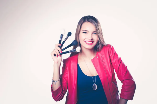 Молодая красивая женщина держит в руке кисть для макияжа  . — стоковое фото