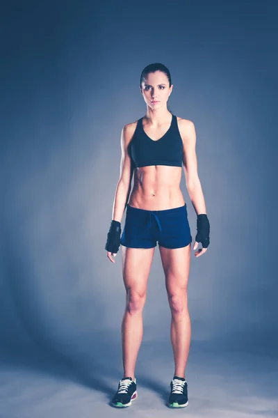 근육 질의 젊은 여성 스포츠웨어 블랙 배경에서 포즈. — 스톡 사진