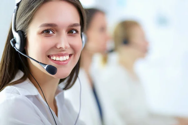 Mujer de negocios sonriente u operador de línea de ayuda con auriculares y computadora en la oficina — Foto de Stock