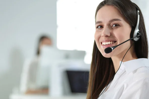 Lächelnde Geschäftsfrau oder Helpline-Betreiberin mit Headset und Computer im Büro — Stockfoto