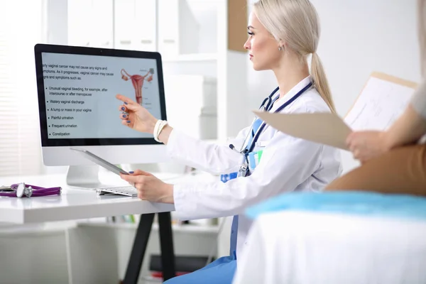 Dokter en patiënt bespreken iets terwijl ze aan tafel zitten. Geneeskunde en gezondheidszorg. Dokter en patiënt — Stockfoto