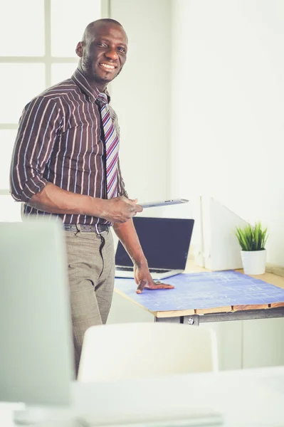 Arquitecto afroamericano trabajando con computadoras y planos en la oficina —  Fotos de Stock