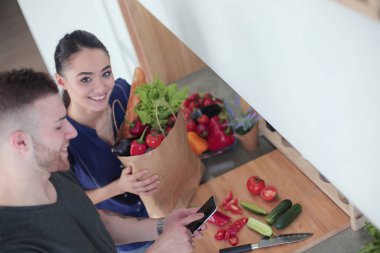 Mutlu çift Smartphone ayakta mutfakta kullanarak