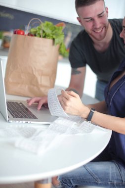 Çift evde mutfak içinde laptop ile onların fatura ödeme