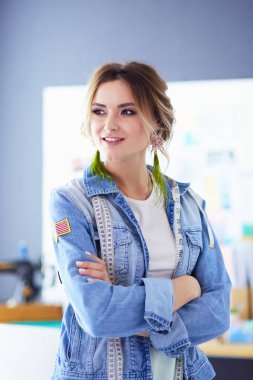 Moda tasarımcısı kadın stüdyoda tasarımları üzerinde çalışıyor.