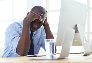 Kulaklıklı Afro-Amerikan işadamı laptopuyla çalışıyor.