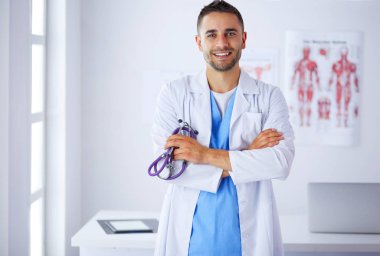 Elinde kahve fincanı olan genç bir doktor.