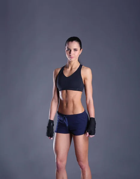 Musculosa joven posando en ropa deportiva sobre fondo negro — Foto de Stock