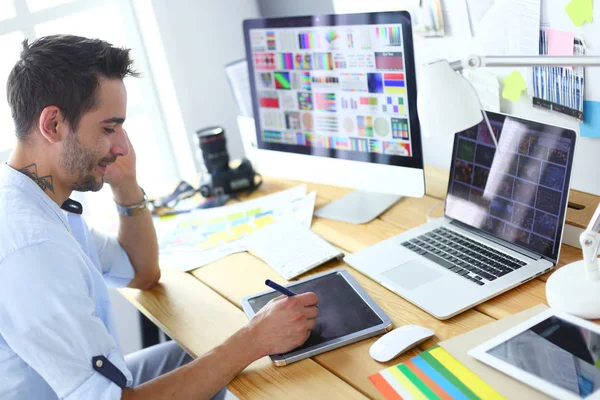 年轻设计师在线工作时坐在笔记本电脑和计算机前的图形工作室的肖像. — 图库照片