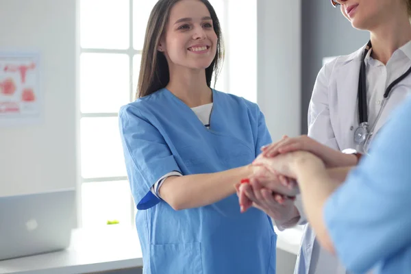 Médicos e enfermeiros em uma equipe médica empilhando mãos — Fotografia de Stock