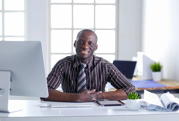 Stilig Afro amerikansk affärsman i klassisk kostym är att använda en laptop och leende medan arbetande i kontor — Stockfoto