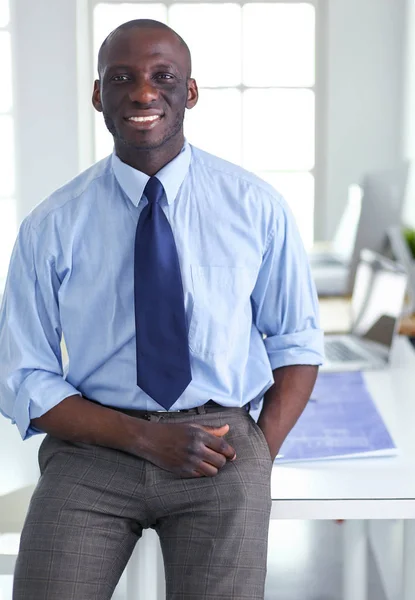 Retrato de un apuesto hombre de negocios negro de pie en el cargo — Foto de Stock