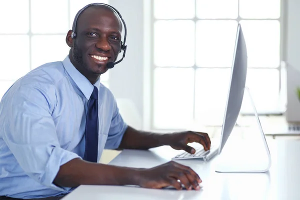 African american businessman on headset working on his laptop — Stock Photo, Image