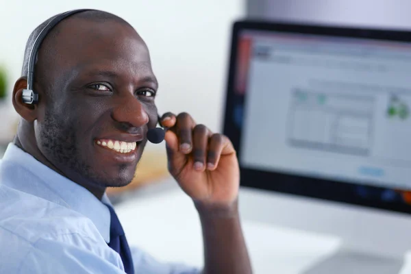 African american businessman on headset working on his laptop — Stock Photo, Image