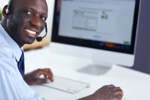 Африканський американський бізнесмен на навушниках працює над ноутбуком — стокове фото