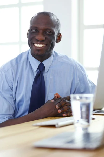 Afrikansk amerikansk affärsman på headset arbetar på sin bärbara dator — Stockfoto