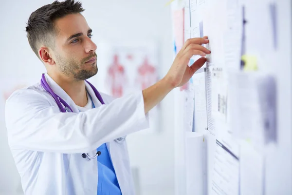 Retrato médico masculino joven y confiado de pie en el consultorio médico — Foto de Stock