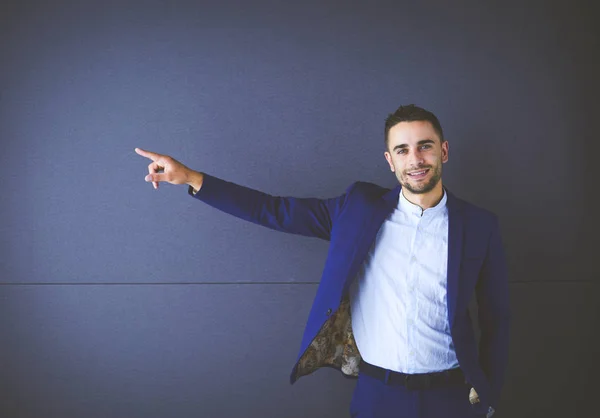 Junger Geschäftsmann steht isoliert auf grauem Hintergrund — Stockfoto