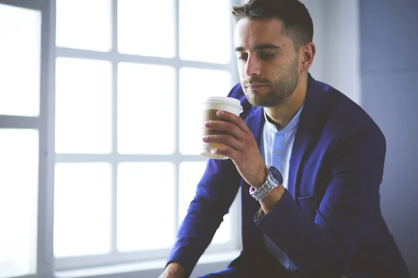 Młody biznesmen pijący filiżankę kawy lub herbaty — Zdjęcie stockowe