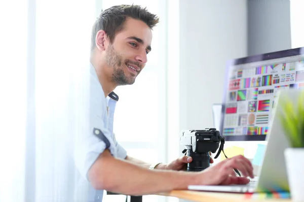 Retrato de jovem designer sentado no estúdio gráfico na frente de laptop e computador enquanto trabalhava online. — Fotografia de Stock