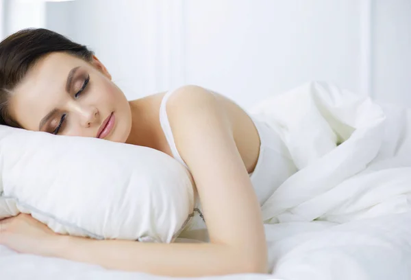 Νεαρή όμορφη γυναίκα ξαπλωμένη στο κρεβάτι — Φωτογραφία Αρχείου