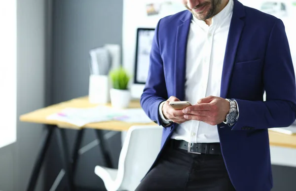 Joven diseñador escribiendo sms en su oficina —  Fotos de Stock