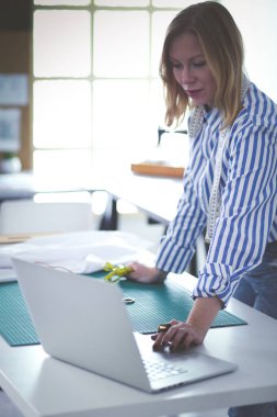 moda tasarımcısı olarak stüdyonun tasarımları üzerinde çalışıyor